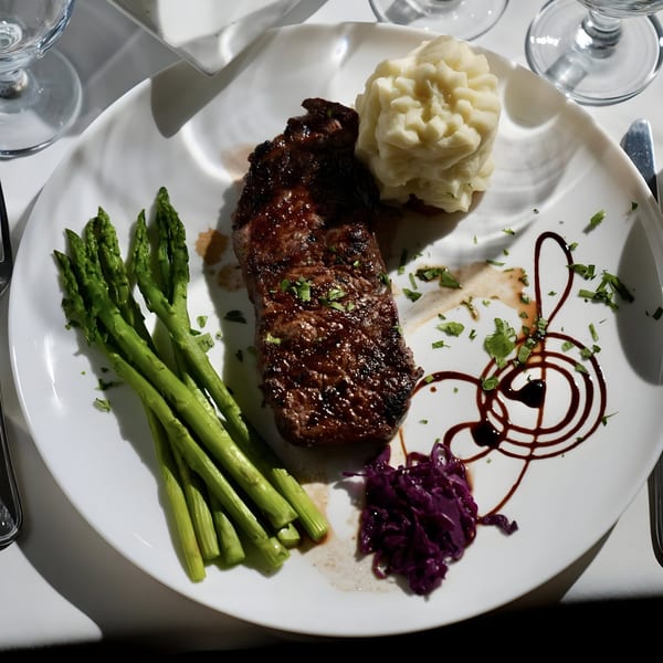 Assado Portuguese Steakhouse's grilled steak with asparagus, mashed potatoes, red cabbage, and balsamic glaze.